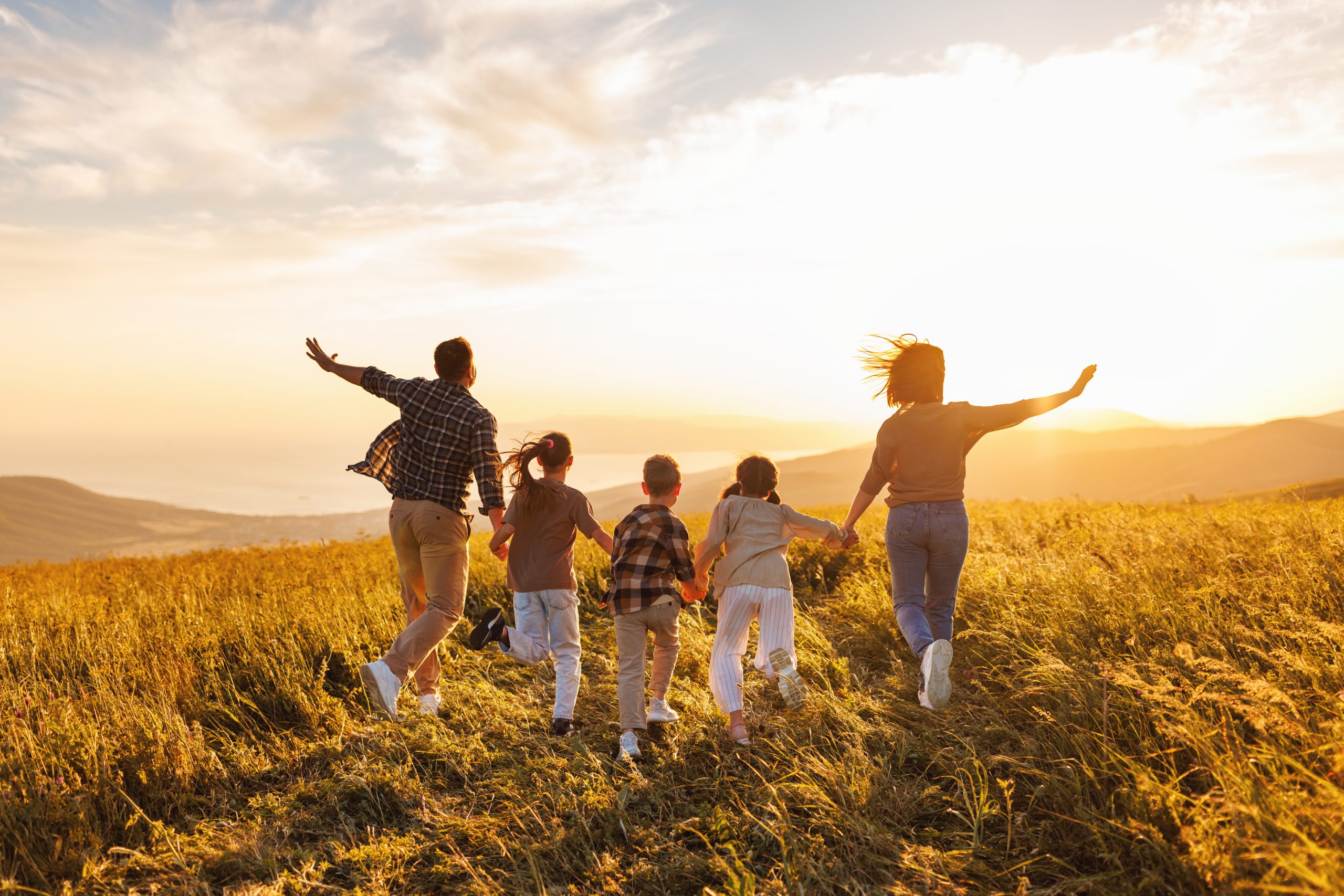 Happy large family: mother, father, children son and daughters running on nature on sunset