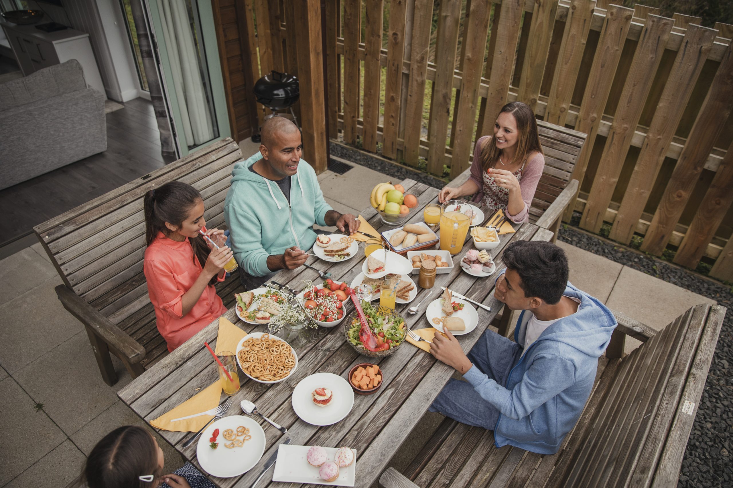 High angle view of family having breakfast outside of a holdiay cottage.